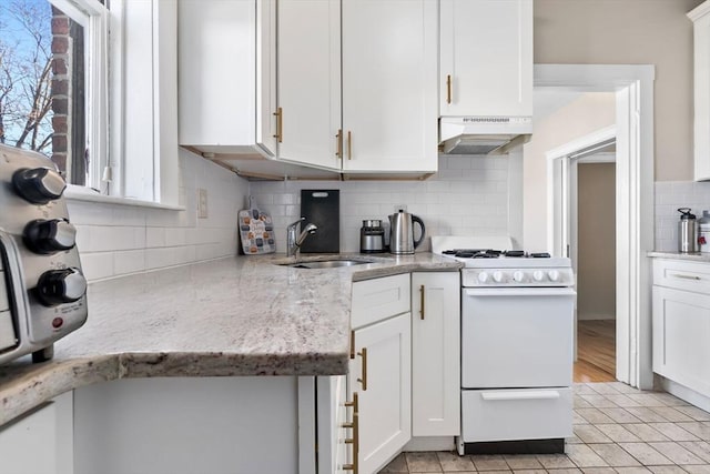 kitchen with sink, white cabinetry, light stone counters, white range with gas cooktop, and decorative backsplash