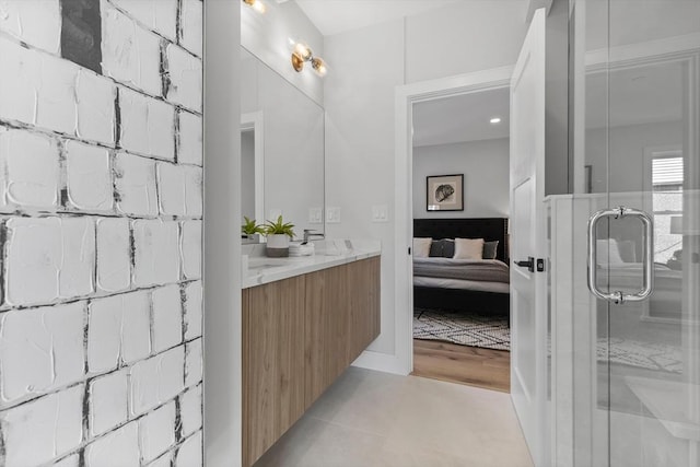 bathroom with an enclosed shower, vanity, and tile patterned floors