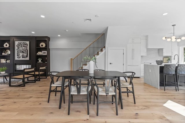 dining area with light hardwood / wood-style floors and sink