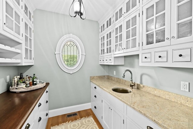 54 Garrison Dr, Scituate, MA 02066 - kitchen featuring a sink, baseboards, dark wood-style floors, white cabinetry, and dark stone counters