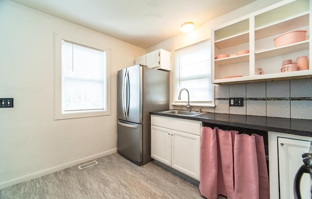 83 Armstrong St, West Springfield, MA 01089 - kitchen with freestanding refrigerator, dark countertops, white cabinetry, light wood-type flooring, and backsplash