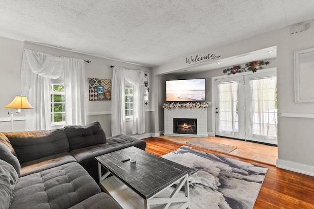 47-49 Dean St, Norton, MA 02766 - living room with a textured ceiling, a tile fireplace, and wood finished floors