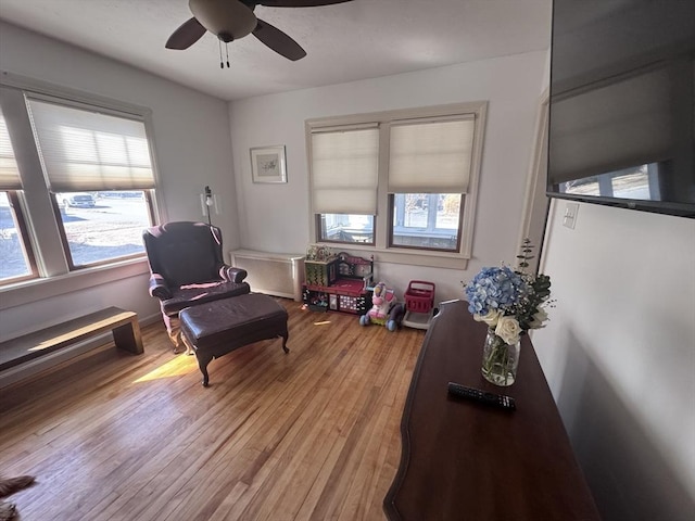 living area with light wood-style floors and ceiling fan