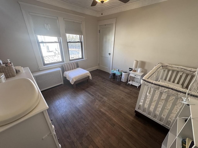 bedroom featuring dark wood finished floors, crown molding, radiator heating unit, and ceiling fan