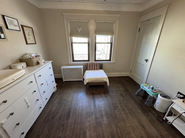 unfurnished bedroom with radiator heating unit, dark wood-style floors, baseboards, and an ornate ceiling