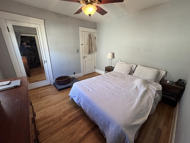 bedroom with wood finished floors, baseboards, and ceiling fan