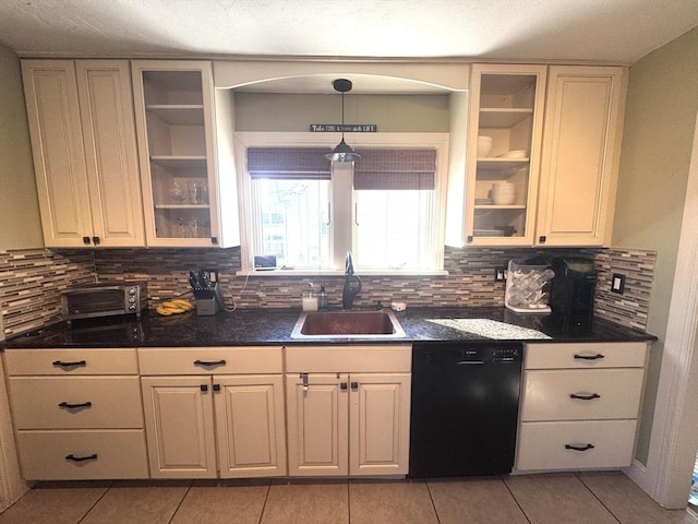 kitchen featuring dark countertops, tasteful backsplash, glass insert cabinets, dishwasher, and a sink