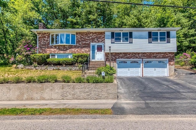 126 Scott Cir, Dedham, MA 02026 - bi-level home featuring a chimney, entry steps, an attached garage, asphalt driveway, and brick siding