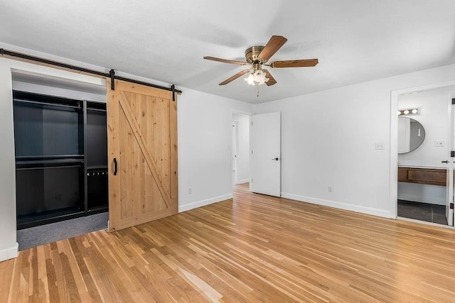 126 Scott Cir, Dedham, MA 02026 - unfurnished bedroom with light wood-style floors, baseboards, a barn door, ensuite bathroom, and ceiling fan