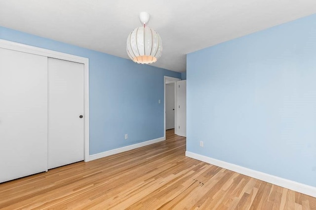 126 Scott Cir, Dedham, MA 02026 - unfurnished bedroom with baseboards, wood finished floors, and a closet