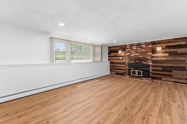 126 Scott Cir, Dedham, MA 02026 - unfurnished living room featuring a wood stove, wood finished floors, wooden walls, and a baseboard heating unit