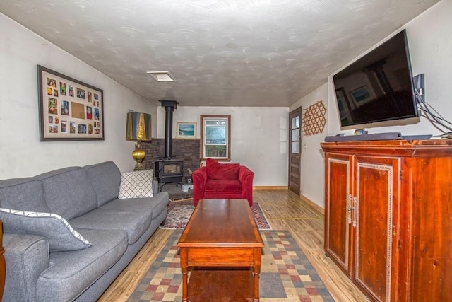 8 N Longyard Rd, Southwick, MA 01077 - living room featuring a wood stove, wood finished floors, and baseboards