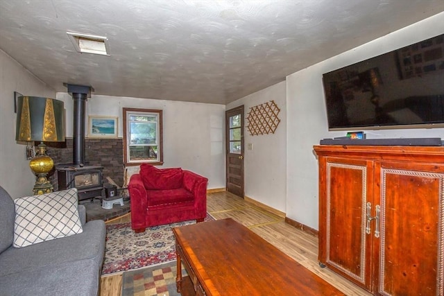 8 N Longyard Rd, Southwick, MA 01077 - living room with wood finished floors, a wood stove, and baseboards