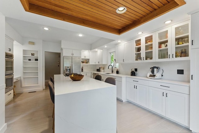 18 Alden St, Newton, MA 02459 - kitchen with stainless steel appliances, wood ceiling, a tray ceiling, white cabinetry, and a kitchen island