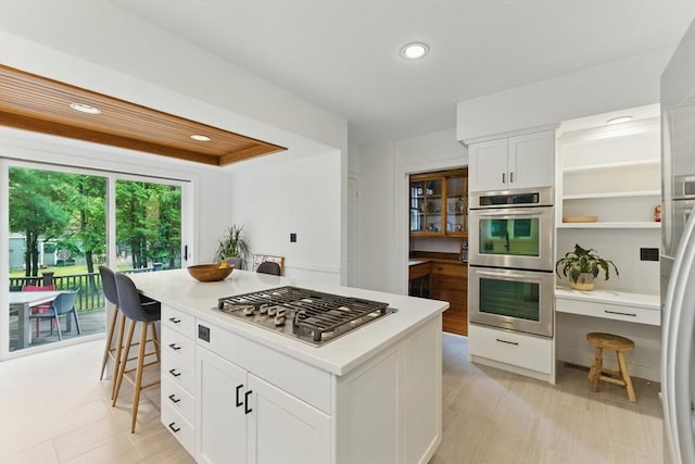 18 Alden St, Newton, MA 02459 - kitchen with stainless steel appliances, white cabinetry, light countertops, a kitchen breakfast bar, and recessed lighting