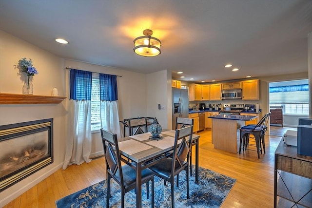 143 Eagle St, Ware, MA 01082 - dining room featuring recessed lighting, baseboards, light wood-style flooring, and a glass covered fireplace