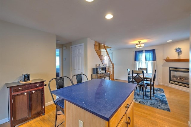 143 Eagle St, Ware, MA 01082 - kitchen with recessed lighting, a kitchen bar, light wood-style flooring, a kitchen island, and baseboards