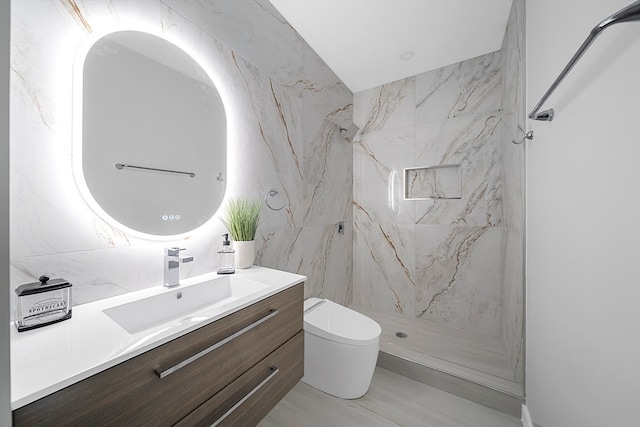 bathroom with vanity, toilet, and tile walls