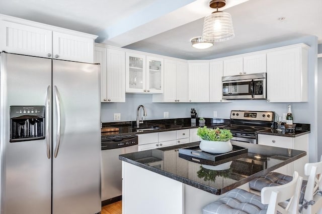 606 W Falmouth Hwy Unit 7, Falmouth, MA 02540 - kitchen featuring white cabinets, appliances with stainless steel finishes, a breakfast bar area, and a sink