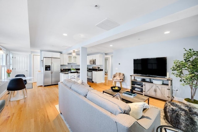 606 W Falmouth Hwy Unit 7, Falmouth, MA 02540 - living room featuring baseboards, light wood-style floors, and visible vents