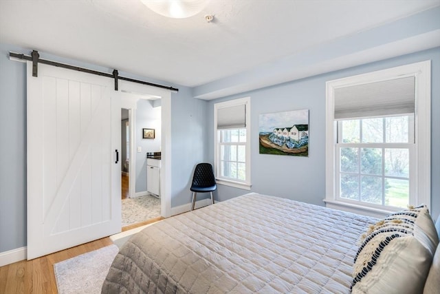 606 W Falmouth Hwy Unit 7, Falmouth, MA 02540 - bedroom with multiple windows, light wood-style flooring, baseboards, and a barn door