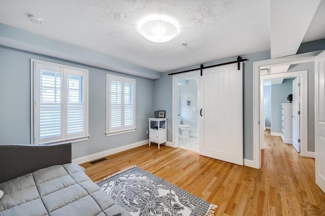 606 W Falmouth Hwy Unit 7, Falmouth, MA 02540 - interior space with a barn door, baseboards, light wood-style floors, and visible vents