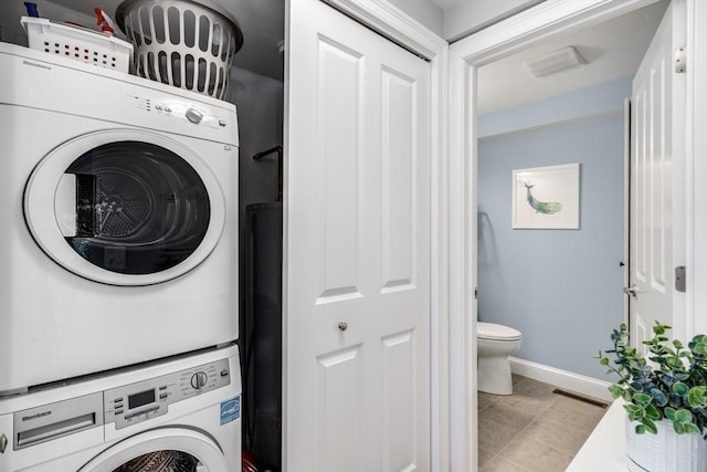 606 W Falmouth Hwy Unit 7, Falmouth, MA 02540 - washroom featuring stacked washer and clothes dryer, laundry area, visible vents, light tile patterned floors, and baseboards