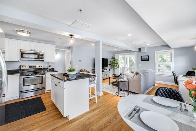 606 W Falmouth Hwy Unit 7, Falmouth, MA 02540 - kitchen featuring dark countertops, open floor plan, stainless steel appliances, and white cabinets