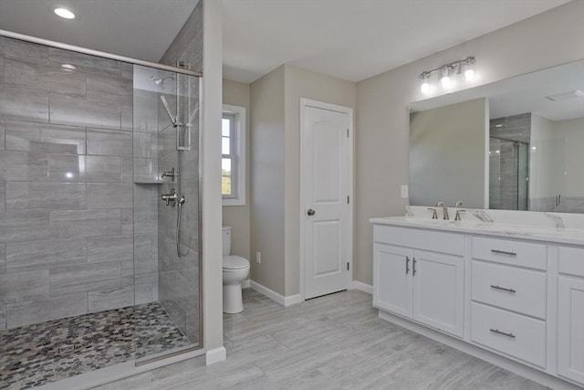 bathroom with a shower stall, vanity, baseboards, toilet, and recessed lighting