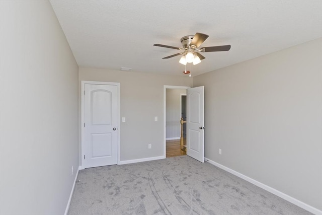 unfurnished bedroom featuring carpet floors, a ceiling fan, and baseboards