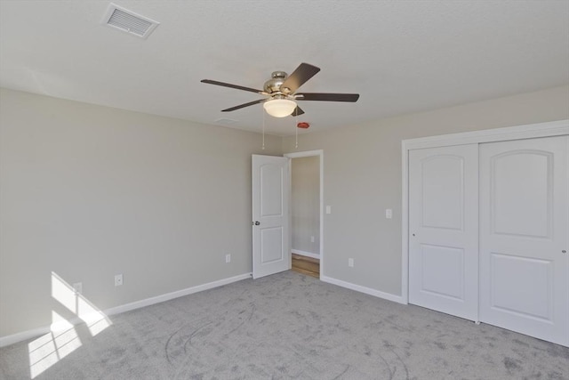 unfurnished bedroom with baseboards, carpet, a closet, and visible vents