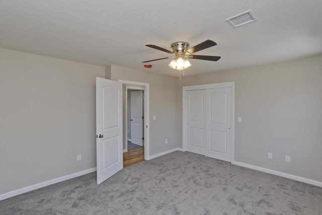 unfurnished bedroom with visible vents, carpet, baseboards, and a closet