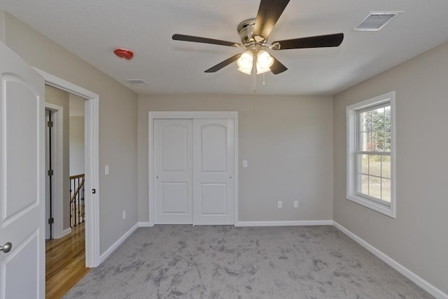 unfurnished bedroom with baseboards, a closet, carpet floors, and visible vents