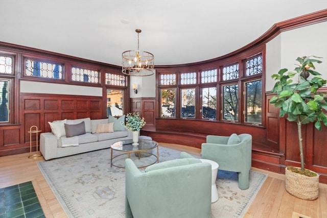 interior space with a chandelier, wood finished floors, and a decorative wall