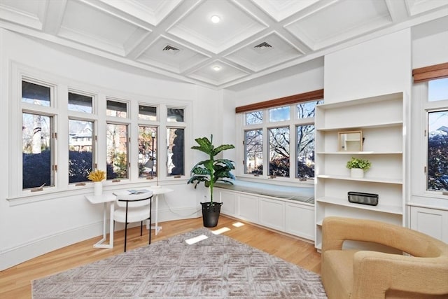 living area featuring light wood-type flooring, beamed ceiling, coffered ceiling, and visible vents