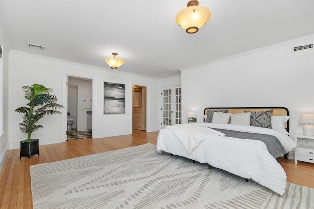 bedroom with visible vents, wood finished floors, and ornamental molding