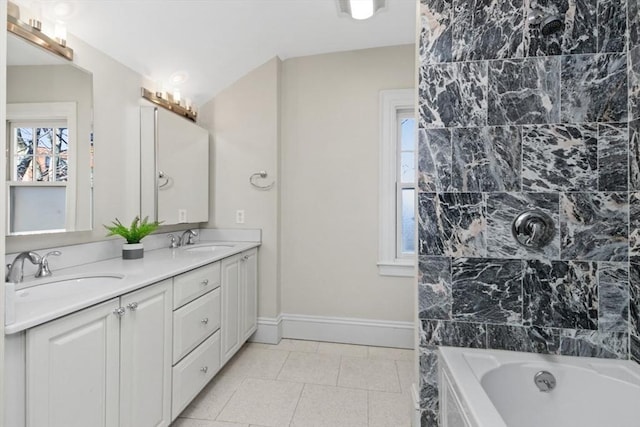 bathroom with double vanity, tile patterned flooring, baseboards, and a sink