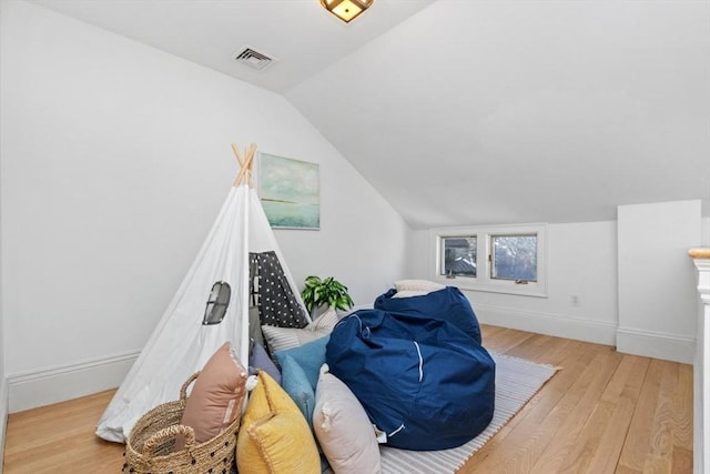 additional living space featuring vaulted ceiling, light wood-style flooring, visible vents, and baseboards