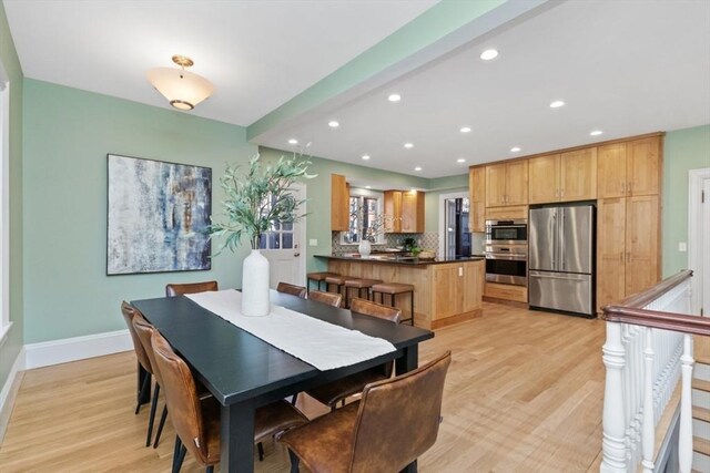 dining room with light wood-type flooring, baseboards, and recessed lighting