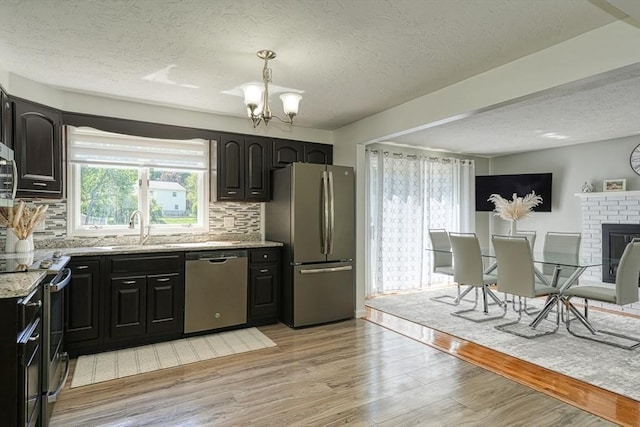 13 Woodland Dr, Hudson, MA 01749 - kitchen with appliances with stainless steel finishes, a textured ceiling, light stone counters, a chandelier, and tasteful backsplash