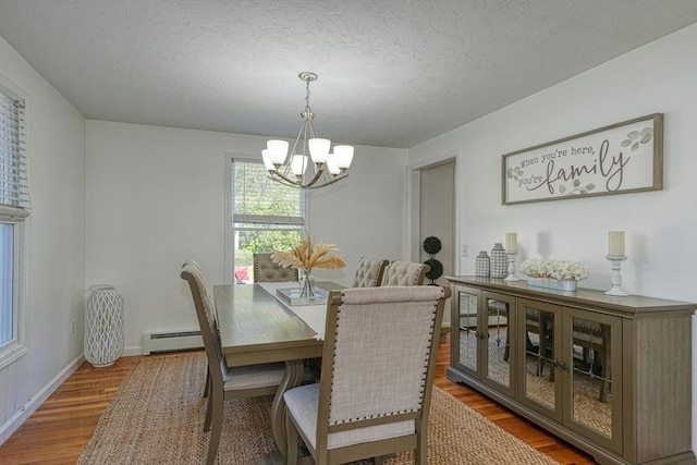 13 Woodland Dr, Hudson, MA 01749 - dining room featuring a chandelier, baseboard heating, wood finished floors, a textured ceiling, and baseboards