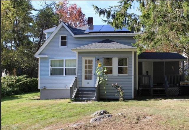 31 Benham St, Orange, MA 01364 - view of front of home with solar panels, a front lawn, a chimney, and roof with shingles