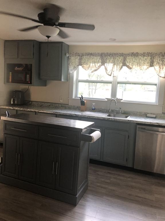 31 Benham St, Orange, MA 01364 - kitchen with stainless steel dishwasher, black microwave, ceiling fan, and dark wood finished floors