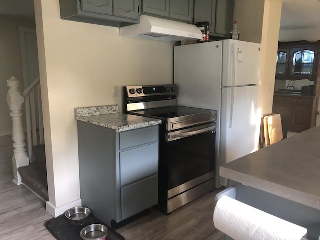 31 Benham St, Orange, MA 01364 - kitchen with stainless steel range with electric stovetop, extractor fan, dark wood-type flooring, and light countertops