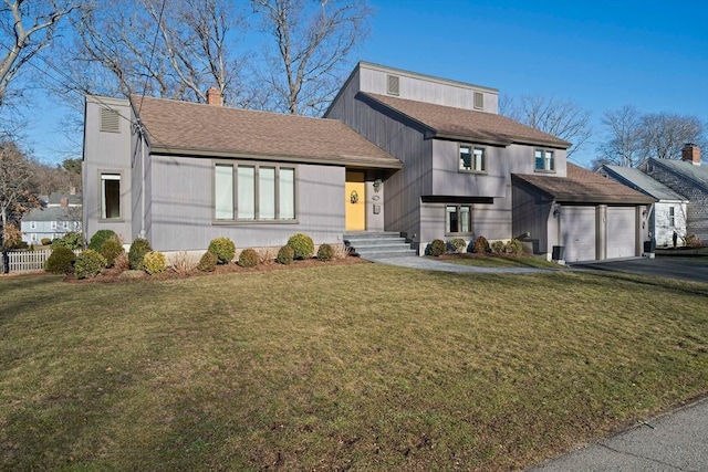 view of front of home with a front lawn, an attached garage, fence, and aphalt driveway