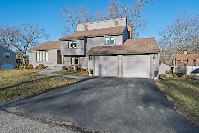 view of front of home featuring a garage, aphalt driveway, a front yard, and fence