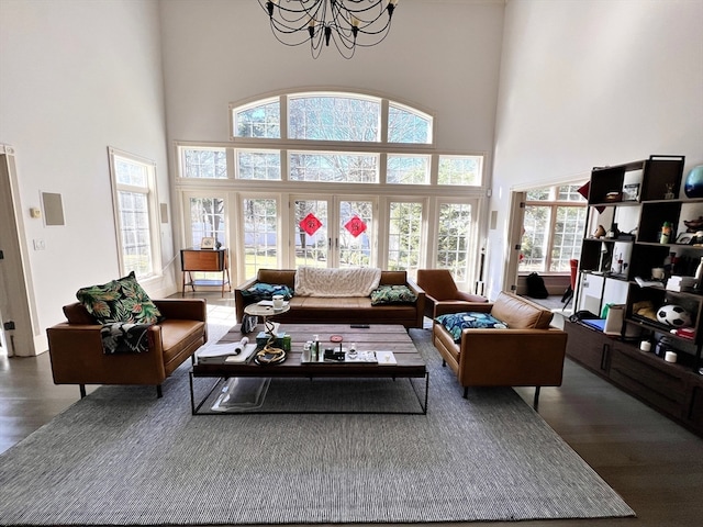 living room featuring a high ceiling, a notable chandelier, and dark hardwood / wood-style flooring