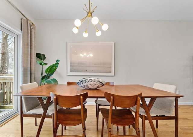 dining area with light hardwood / wood-style floors and a chandelier