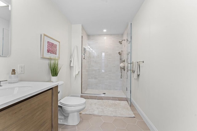 bathroom with tile patterned floors, vanity, toilet, and a shower with door