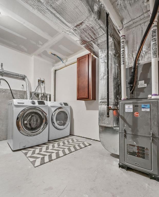 clothes washing area featuring cabinets and independent washer and dryer